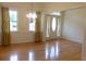 Bright living room featuring hardwood floors, large windows with gold curtains, and an elegant chandelier at 430 English Ivy Way, Woodstock, GA 30188