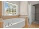 Bright bathroom featuring a large soaking tub and a sunlit window at 795 Creek Glen Rd, Mableton, GA 30126