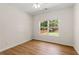 A simple bedroom featuring wood floors and a window with a view of the trees at 795 Creek Glen Rd, Mableton, GA 30126