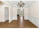 An elegant dining room with paneled walls, hardwood floors, and a modern chandelier at 795 Creek Glen Rd, Mableton, GA 30126