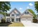 Charming two-story home with a two-car garage, a well-manicured lawn, and lovely landscaping at 795 Creek Glen Rd, Mableton, GA 30126