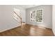 Sunlit living room with hardwood floors, staircase view, and a large window showcasing the front yard at 795 Creek Glen Rd, Mableton, GA 30126