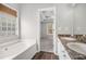A bathroom with double sinks, a large mirror, a window, and a soaking tub at 104 Terrapin Ct, Carrollton, GA 30116
