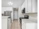 Cozy kitchen with stainless steel appliances, tiled floors, white cabinetry, and a view of the hall at 104 Terrapin Ct, Carrollton, GA 30116