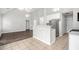 Open-concept layout featuring wood flooring, a breakfast bar, stainless steel appliances, and vaulted ceilings at 104 Terrapin Ct, Carrollton, GA 30116