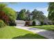Single-story home with an attached garage, long driveway, and mature trees enhancing the property's appeal at 3519 Oak Knoll Dr, Marietta, GA 30068