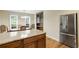 Kitchen island with stone counter, stainless refrigerator, breakfast area with windows, wooden floor, and light fixture at 3519 Oak Knoll Dr, Marietta, GA 30068