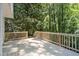 Spacious wooden deck with natural wood railing surrounded by lush greenery at 4166 Riverhill Ne Ct, Roswell, GA 30075
