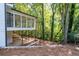 Backyard view showing the white house, sunroom, and surrounding trees at 4166 Riverhill Ne Ct, Roswell, GA 30075