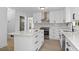 A modern kitchen with white cabinetry, stainless steel appliances, and a large island at 4166 Riverhill Ne Ct, Roswell, GA 30075