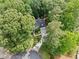 Aerial view of a home nestled among mature trees with a circular driveway at 4402 Windsor Oaks Chase, Marietta, GA 30066