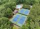 Bird's eye view of community tennis courts and a swimming pool surrounded by green trees at 4402 Windsor Oaks Chase, Marietta, GA 30066