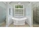 Bright bathroom featuring a soaking tub below a window, and glass enclosed shower at 4402 Windsor Oaks Chase, Marietta, GA 30066