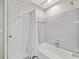 This full bathroom features gray tile, a shower head, and a shower curtain for privacy at 4402 Windsor Oaks Chase, Marietta, GA 30066