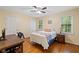 Bedroom with hardwood floors, ceiling fan, and two windows facing the wooded area at 4402 Windsor Oaks Chase, Marietta, GA 30066