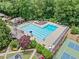 Stunning aerial view of a sparkling community pool, cabana, playground and tennis courts surrounded by lush greenery at 4402 Windsor Oaks Chase, Marietta, GA 30066