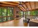 Inviting sunroom with wood floors, a stone fireplace, and walls of windows overlooking the private backyard at 4402 Windsor Oaks Chase, Marietta, GA 30066