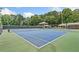 Tennis courts features a pristine surface and net, surrounded by lush greenery at 4402 Windsor Oaks Chase, Marietta, GA 30066