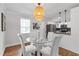 Cozy dining area with glass table, white chairs, and decorative lighting fixture above at 2048 Mcafee Rd, Decatur, GA 30032