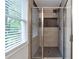Modern tiled shower featuring glass doors, gray tile, and a rain shower head at 2048 Mcafee Rd, Decatur, GA 30032