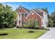 Charming two-story brick home with manicured front lawn, mature landscaping, and driveway at 2330 Springmonte Pl, Cumming, GA 30041