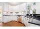 Modern kitchen featuring white cabinets, stainless steel appliances, and dark granite countertops at 2330 Springmonte Pl, Cumming, GA 30041
