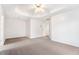 Spacious main bedroom with tray ceiling, ceiling fan, and neutral carpet at 2330 Springmonte Pl, Cumming, GA 30041