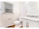 Updated powder room boasts white vanity, round mirror, wood floors and toilet at 2330 Springmonte Pl, Cumming, GA 30041