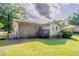 View of backyard with green grass, foliage, and a small deck off the back of the brick and vinyl sided home at 3420 Leisure Ln, Atlanta, GA 30349