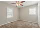 This bedroom has a ceiling fan, plush carpet, a closet and two windows for natural light at 3420 Leisure Ln, Atlanta, GA 30349