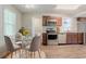 Cozy kitchen with stainless steel appliances, brown cabinets, wood-look flooring, and a dining area nearby at 3420 Leisure Ln, Atlanta, GA 30349