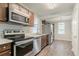 Bright kitchen featuring stainless steel appliances, wood cabinets, and new luxury vinyl plank flooring at 3420 Leisure Ln, Atlanta, GA 30349