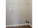 Bright laundry area with wood-look flooring, utility connections, and wire shelving at 3420 Leisure Ln, Atlanta, GA 30349