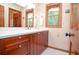 Bathroom showcasing warm wood cabinetry, natural light and a neutral color palette at 4366 Cedar Wood Sw Dr, Lilburn, GA 30047