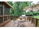 Outdoor deck features grill, table with umbrella, and is surrounded by mature shade trees in a peaceful setting at 4366 Cedar Wood Sw Dr, Lilburn, GA 30047