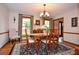 Traditional dining room features hardwood floors, a decorative rug, and an elegant chandelier at 4366 Cedar Wood Sw Dr, Lilburn, GA 30047