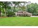 Charming two-story brick home with lush landscaping and mature trees, creating a welcoming curb appeal at 4366 Cedar Wood Sw Dr, Lilburn, GA 30047