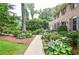 Walkway leading to a brick home, enhanced by colorful, mature landscaping and beautiful yard at 4366 Cedar Wood Sw Dr, Lilburn, GA 30047