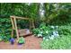 Relaxing backyard retreat with a wooden swing, surrounded by vibrant hydrangeas and lush foliage at 4366 Cedar Wood Sw Dr, Lilburn, GA 30047