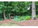 Tranquil backyard garden featuring a cozy wooden swing nestled amongst lush greenery and colorful hydrangeas at 4366 Cedar Wood Sw Dr, Lilburn, GA 30047