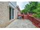 Backyard brick patio with stairs to the deck, wooded area, and exterior air conditioner at 456 Harmony Grove Rd, Lilburn, GA 30047