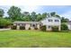 Charming two-story home featuring a lush green lawn and mature landscaping at 456 Harmony Grove Rd, Lilburn, GA 30047