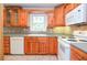 Kitchen featuring light wood cabinets, white appliances, and tiled countertops at 456 Harmony Grove Rd, Lilburn, GA 30047