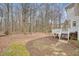 Spacious backyard bordered by mature trees, featuring a wooden deck, steps, and mulch at 465 Woodbrook Ways, Lawrenceville, GA 30043
