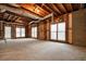 Unfinished basement space showing exposed beams and a concrete floor with natural light from windows at 465 Woodbrook Ways, Lawrenceville, GA 30043