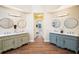 Bright bathroom with dual sink vanities, decorative mirrors, and hardwood floors at 465 Woodbrook Ways, Lawrenceville, GA 30043