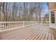 Spacious wood deck with white railings provides a view of the serene wooded backyard at 465 Woodbrook Ways, Lawrenceville, GA 30043