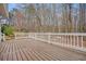Wooden deck with white railing overlooking a wooded backyard offering an ideal space for outdoor living at 465 Woodbrook Ways, Lawrenceville, GA 30043