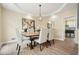 Bright dining room with a long wood table, seating for six, modern lighting, and hardwood floors at 465 Woodbrook Ways, Lawrenceville, GA 30043
