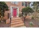 Inviting entrance with a striking pink front door, brick steps, black railing, and manicured landscaping at 465 Woodbrook Ways, Lawrenceville, GA 30043